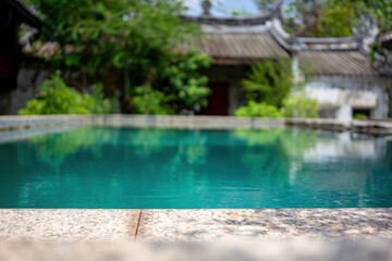 Tranquil Poolside Oasis - The calm waters of a secluded pool reflect the lush greenery of a traditional courtyard setting.
