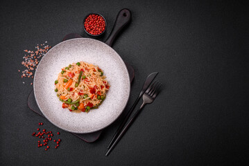 Delicious boiled rice with vegetables peppers, green peas, salt, spices and herbs