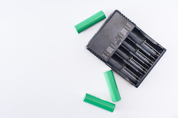 a charger for various types of batteries and nearby batteries. white background.