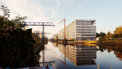 Construction site of a modern office building by a river or canal in Berlin Neukölln