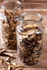 Collect and dry mushrooms in autumn, porcini mushrooms in a jar - a delicious ingredient for sauces and goulash on a wooden table