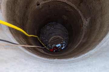 a pump lowered into a deep well for pumping out water