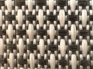 Intertwined threads of fabric surface with black and white pattern.