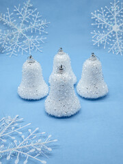 New Year's still life, four Christmas tree decorations in the form of bells with white snowflakes...
