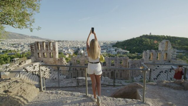 A girl taking a photo at the Acropolis, Athens