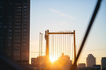 sun rising behind silhouette of skyscraper frame