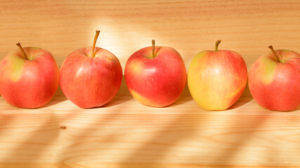 Apples on a wooden table on a sunny day in the kitchen
