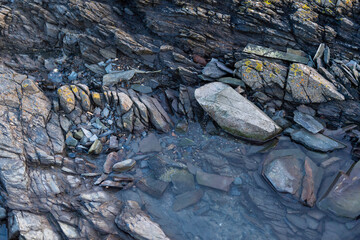 imagen detalle textura piedras laminadas de distintos tamaños, formas y grosores con un poco de agua