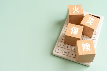 火災保険の文字が入ったブロックと電卓