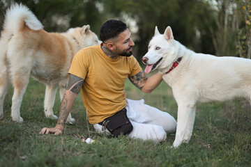 young man with his two nordic dogs on the grass