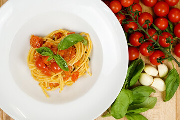 garnishing spaghetti with basil leaf, traditional italian food