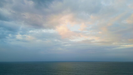 Fototapeta na wymiar Dramatic sky dark ocean at twilight. Aerial rays breaking clouds over sea water.
