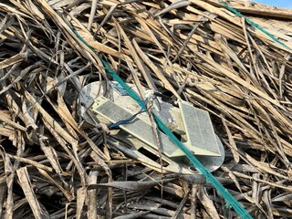 super rough and bleached solar panel on a palm tree roof at the beach