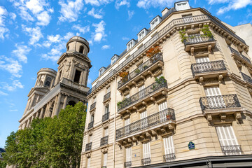 Glimpse of a typical and elegant residential building near place Saint Sulpice in Paris city center, France, with wrought iron railings and balconies 