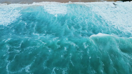 Stunning aerial sea waves breaking on seashore. Ocean surf rolling to beach.