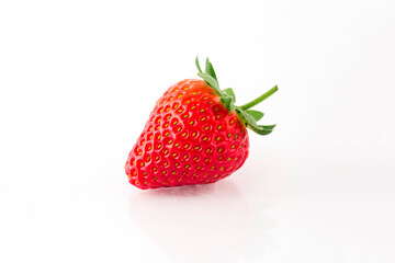 Fresh organic strawberries on a white reflective surface. Close up shot.