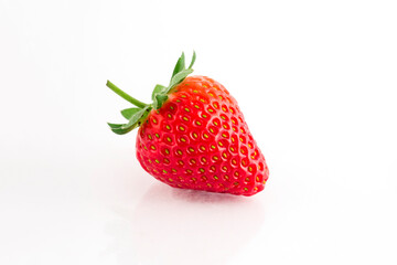 Fresh organic strawberries on a white reflective surface. Close up shot.