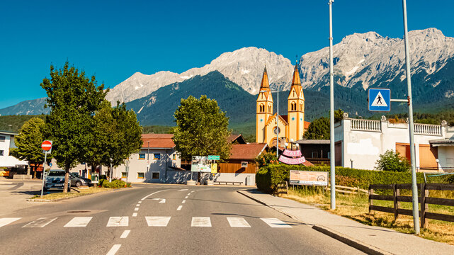Street view with a church and the famous Nordkette mountains at Telfs, Tyrol, Austria