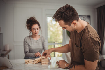 Young woman and man couple playing board games at home, having fun and enjoying weekend vacation