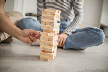 Young couple woman and man play Jenga game at home