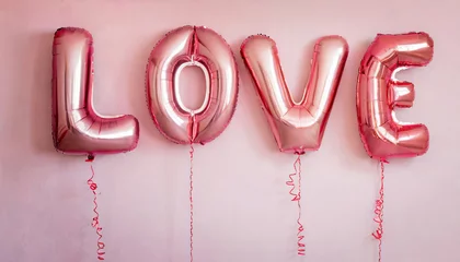 Poster balloons words love hanging on pink wall  valentines day concept © Paula
