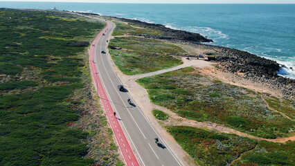 Aerial view seashore road running along rocky coast. Transport riding on highway