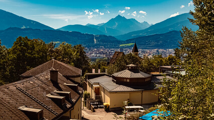 Alpine summer view with the famous Berg Isel Ski Jump Tower and Mount Serles in the background seen from Innsbruck, Austria - obrazy, fototapety, plakaty