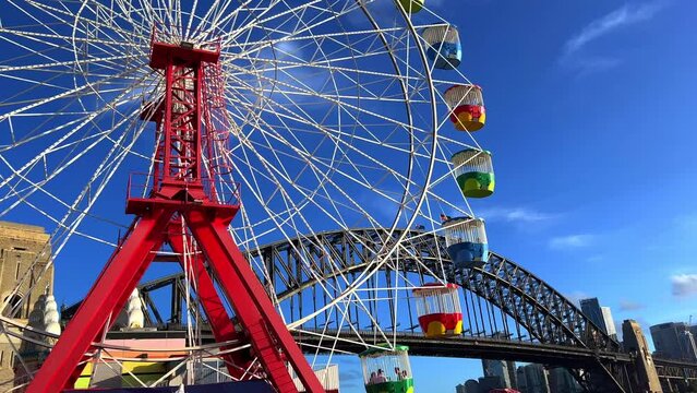 colourful Ferris wheel in Sydney amusement Theme Park with Sydney harbour Bridge in the background NSW Australia 
