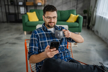 Adult man use mobile phone smartphone at home browse internet or send text messages sms texting