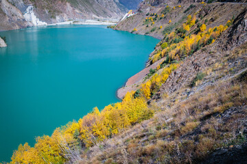 Fototapeta na wymiar Tranquil Blue Reservoir Amidst the Serene Mountain Landscape with Lush Vegetation