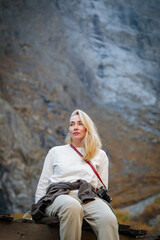 Natural Seclusion: A Girl on a Bridge by a Waterfall in the Mountains