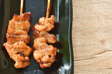 roasted slice chicken dressing Japanese teriyaki sauce stabbing wooden stick on plate