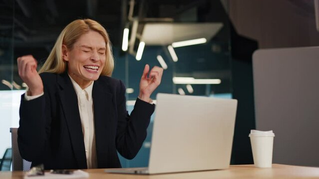 Business lady girl woman female user winner holds her face typing laptop surprised yes gesture delight good news happiness winning opportunity new job notification computer game victory best offer.