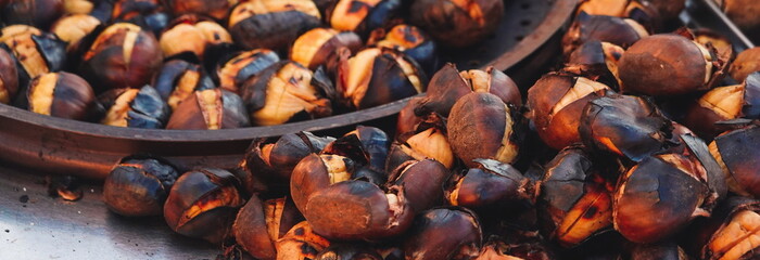 Hot chestnuts roasted on a grill with their skin on. Close-up. Turkey, Istanbul. Selective Focus....