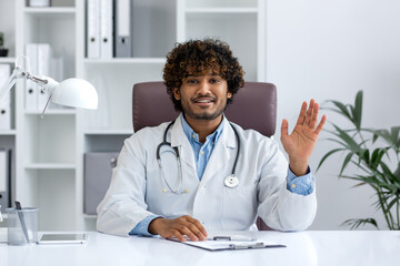 Webcam view, online video call consultation, young Indian doctor in white medical coat looking at...