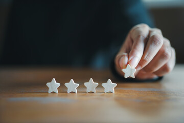 Customer Experience Concept. Man hand showing on five star excellent rating on background, copy...