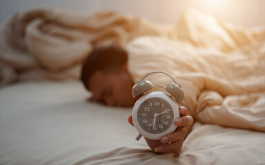 Man turning off alarm clock in bedroom
