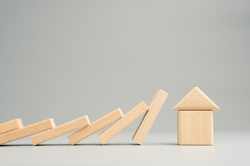 Domino effect is going to impact the wooden toy house, security in economic crisis, insurance concept
