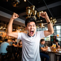 Ecstatic Asian man celebrating victory in a sports bar