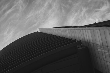 Abstract upward view of a modern buildings sharp lines against a dramatic sky, emphasizing urban architectural design