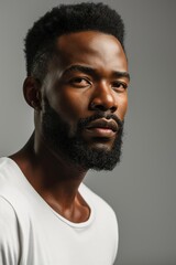 Profile portrait of young hadsome serious bearded African American man on the grey background