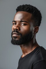 Obraz premium Profile portrait of young hadsome serious bearded African American man on the grey background