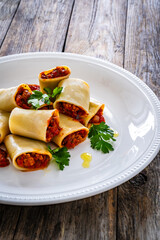 Paccheri con ragù alla bolognese - noodles with bolognese  sauce on wooden table