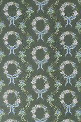 decorative holiday scrapbooking sheet background featuring wreathes composed of small stylized poinsettias and blue ribbons