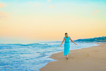 Beautiful mid adult woman walking on sunny beach 