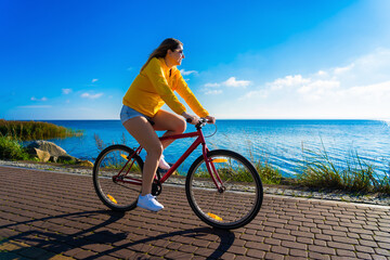 Woman riding bike at seaside
