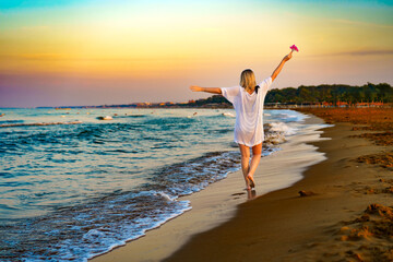Beautiful woman walking on sunny beach - obrazy, fototapety, plakaty