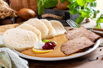 Typical Czech food svickova with beef slices, cream sauce and bread dumplings on the table