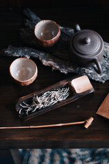 Desde arriba teteras tazas de té y té en hebras en la mesa