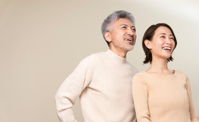 日本人ミドル世代夫婦のポートレート/2人で遠くを見つめている。